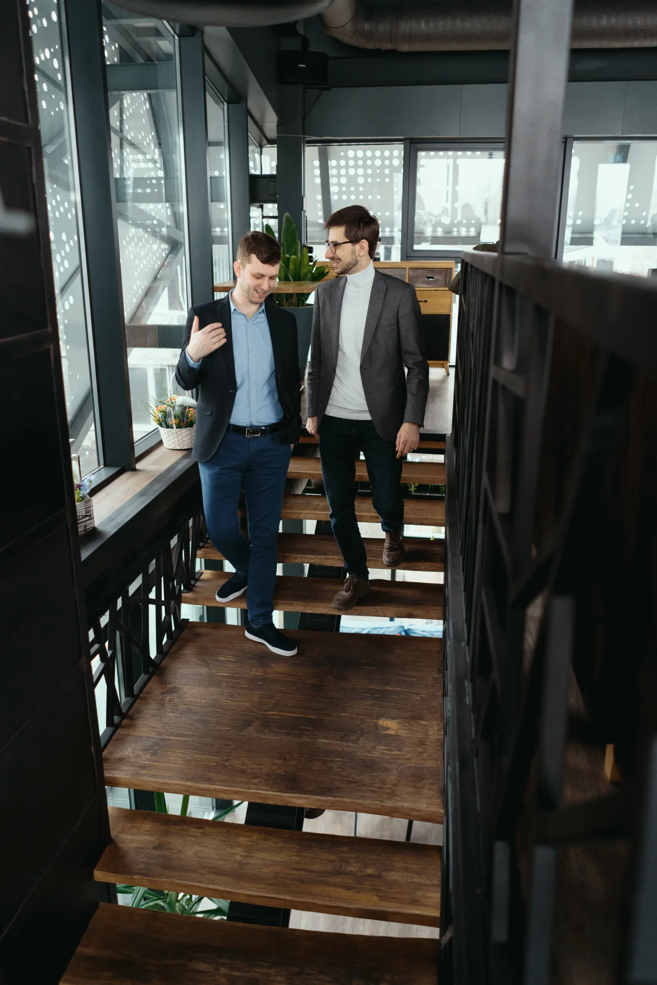 two men walking down stairs chatting indoors