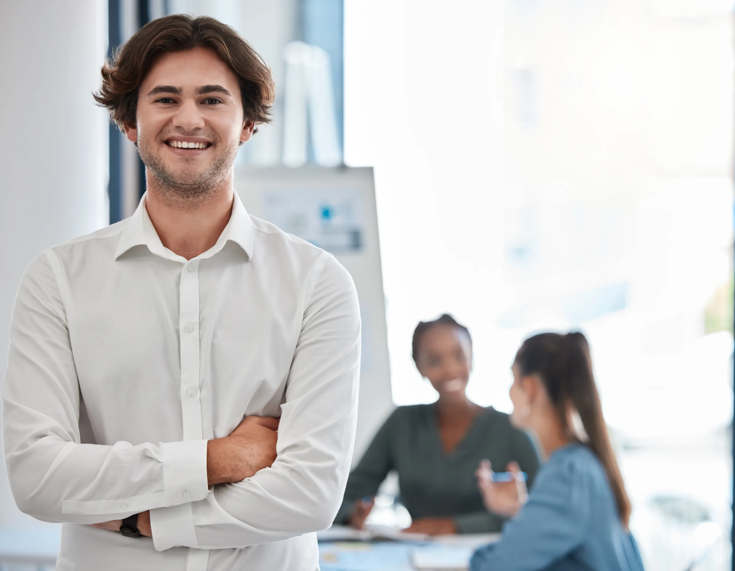 leadership, manager and smile of a young man standing with arms crossed in a boardroom meeting for motivation, innovation and success. confident, happy and professional entrepreneur at the office